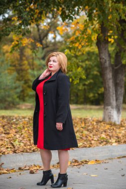 Klasik görünümlü orta yaşlı kadın parka bakıyor, tombul bayanlar için şık bir tarz. Olgun moda artı boyut kadın, orta yaşlı kadın yaşam tarzı kavramı.