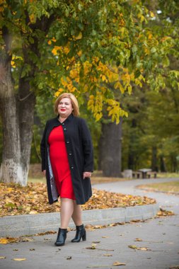 Klasik görünümlü orta yaşlı kadın parka bakıyor, tombul bayanlar için şık bir tarz. Olgun moda artı boyut kadın, orta yaşlı kadın yaşam tarzı kavramı.