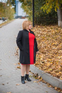 Klasik görünümlü orta yaşlı kadın parka bakıyor, tombul bayanlar için şık bir tarz. Olgun moda artı boyut kadın, orta yaşlı kadın yaşam tarzı kavramı.