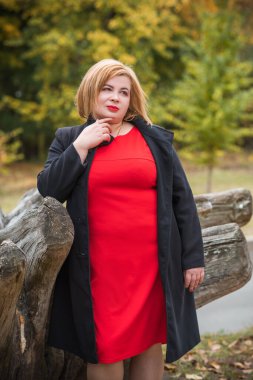 Klasik görünümlü orta yaşlı kadın parka bakıyor, tombul bayanlar için şık bir tarz. Olgun moda artı boyut kadın, orta yaşlı kadın yaşam tarzı kavramı.