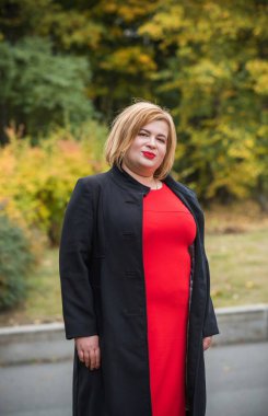 Klasik görünümlü orta yaşlı kadın parka bakıyor, tombul bayanlar için şık bir tarz. Olgun moda artı boyut kadın, orta yaşlı kadın yaşam tarzı kavramı.