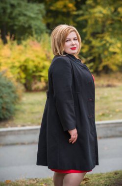 Klasik görünümlü orta yaşlı kadın parka bakıyor, tombul bayanlar için şık bir tarz. Olgun moda artı boyut kadın, orta yaşlı kadın yaşam tarzı kavramı.