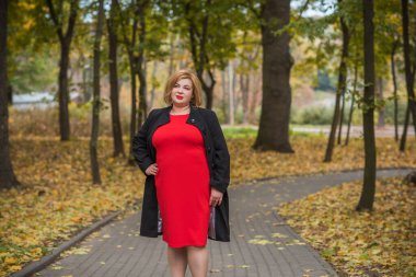 Klasik görünümlü orta yaşlı kadın parka bakıyor, tombul bayanlar için şık bir tarz. Olgun moda artı boyut kadın, orta yaşlı kadın yaşam tarzı kavramı.