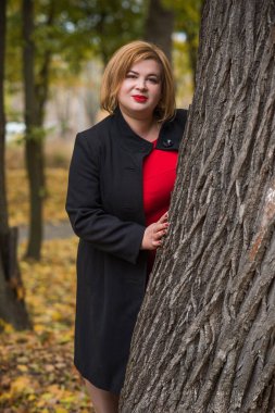 Klasik görünümlü orta yaşlı kadın parka bakıyor, tombul bayanlar için şık bir tarz. Olgun moda artı boyut kadın, orta yaşlı kadın yaşam tarzı kavramı.