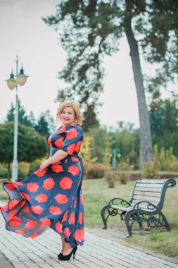 Klasik görünümlü orta yaşlı kadın parka bakıyor, tombul bayanlar için şık bir tarz. Olgun moda artı boyut kadın, orta yaşlı kadın yaşam tarzı kavramı.