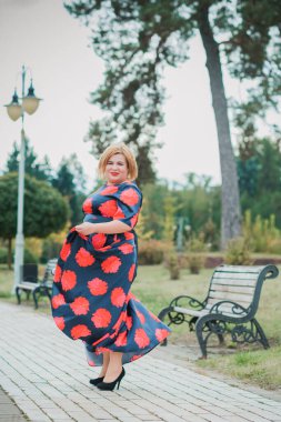 Klasik görünümlü orta yaşlı kadın parka bakıyor, tombul bayanlar için şık bir tarz. Olgun moda artı boyut kadın, orta yaşlı kadın yaşam tarzı kavramı.