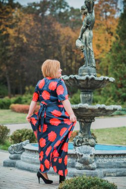 Klasik görünümlü orta yaşlı kadın parka bakıyor, tombul bayanlar için şık bir tarz. Olgun moda artı boyut kadın, orta yaşlı kadın yaşam tarzı kavramı.