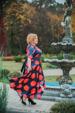 Klasik görünümlü orta yaşlı kadın parka bakıyor, tombul bayanlar için şık bir tarz. Olgun moda artı boyut kadın, orta yaşlı kadın yaşam tarzı kavramı.