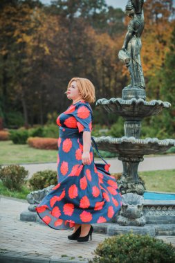 Klasik görünümlü orta yaşlı kadın parka bakıyor, tombul bayanlar için şık bir tarz. Olgun moda artı boyut kadın, orta yaşlı kadın yaşam tarzı kavramı.