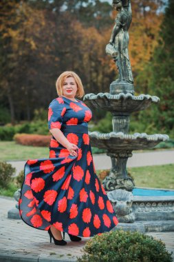 Klasik görünümlü orta yaşlı kadın parka bakıyor, tombul bayanlar için şık bir tarz. Olgun moda artı boyut kadın, orta yaşlı kadın yaşam tarzı kavramı.