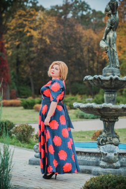 Klasik görünümlü orta yaşlı kadın parka bakıyor, tombul bayanlar için şık bir tarz. Olgun moda artı boyut kadın, orta yaşlı kadın yaşam tarzı kavramı.