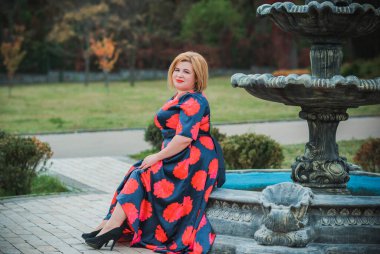 Klasik görünümlü orta yaşlı kadın parka bakıyor, tombul bayanlar için şık bir tarz. Olgun moda artı boyut kadın, orta yaşlı kadın yaşam tarzı kavramı.