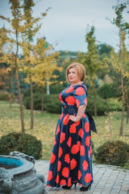 Klasik görünümlü orta yaşlı kadın parka bakıyor, tombul bayanlar için şık bir tarz. Olgun moda artı boyut kadın, orta yaşlı kadın yaşam tarzı kavramı.