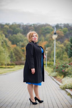 Klasik görünümlü orta yaşlı kadın parka bakıyor, tombul bayanlar için şık bir tarz. Olgun moda artı boyut kadın, orta yaşlı kadın yaşam tarzı kavramı.