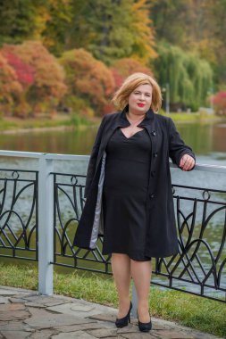 Klasik görünümlü orta yaşlı kadın parka bakıyor, tombul bayanlar için şık bir tarz. Olgun moda artı boyut kadın, orta yaşlı kadın yaşam tarzı kavramı.