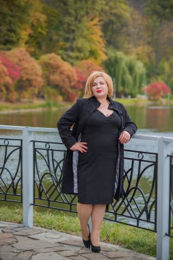 Klasik görünümlü orta yaşlı kadın parka bakıyor, tombul bayanlar için şık bir tarz. Olgun moda artı boyut kadın, orta yaşlı kadın yaşam tarzı kavramı.