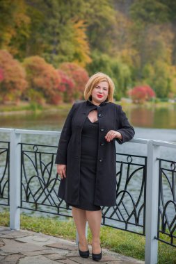 Klasik görünümlü orta yaşlı kadın parka bakıyor, tombul bayanlar için şık bir tarz. Olgun moda artı boyut kadın, orta yaşlı kadın yaşam tarzı kavramı.