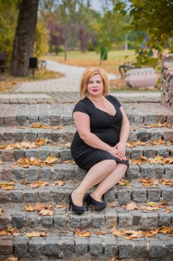 Klasik görünümlü orta yaşlı kadın parka bakıyor, tombul bayanlar için şık bir tarz. Olgun moda artı boyut kadın, orta yaşlı kadın yaşam tarzı kavramı.