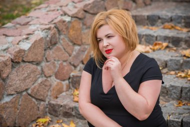 Klasik görünümlü orta yaşlı kadın parka bakıyor, tombul bayanlar için şık bir tarz. Olgun moda artı boyut kadın, orta yaşlı kadın yaşam tarzı kavramı.