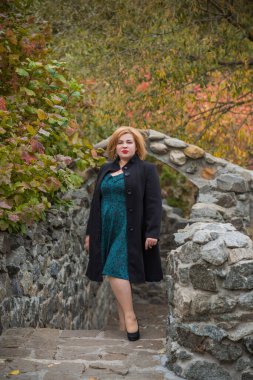 Klasik görünümlü orta yaşlı kadın parka bakıyor, tombul bayanlar için şık bir tarz. Olgun moda artı boyut kadın, orta yaşlı kadın yaşam tarzı kavramı.