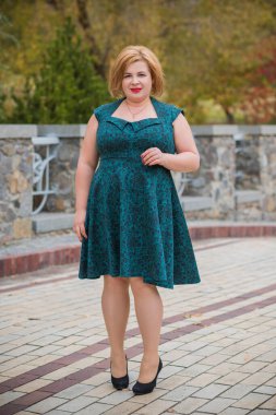 Klasik görünümlü orta yaşlı kadın parka bakıyor, tombul bayanlar için şık bir tarz. Olgun moda artı boyut kadın, orta yaşlı kadın yaşam tarzı kavramı.