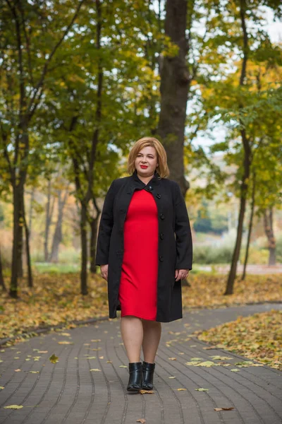 Klasik görünümlü orta yaşlı kadın parka bakıyor, tombul bayanlar için şık bir tarz. Olgun moda artı boyut kadın, orta yaşlı kadın yaşam tarzı kavramı.