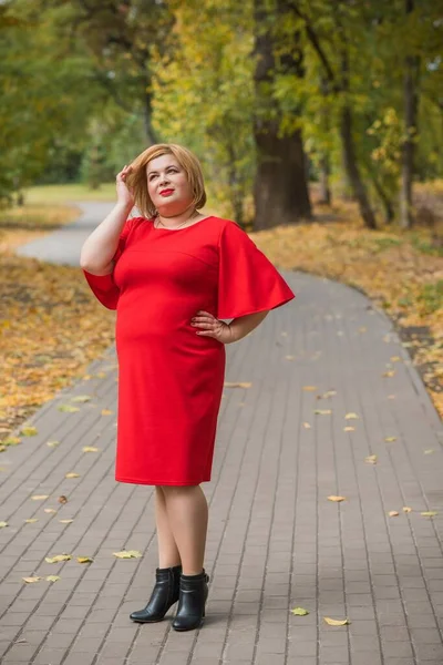 Middle age woman in classical look at park, fashionable style for plump ladies. Mature fashionable plus size woman, concept of middle age lady lifestyle