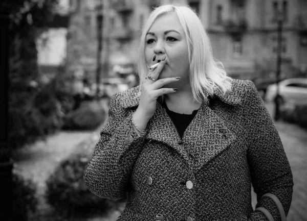 一个相当大的欧洲女孩在室外吸烟过量 妇女吸烟的问题 吸烟对体重和体形的影响 — 图库照片