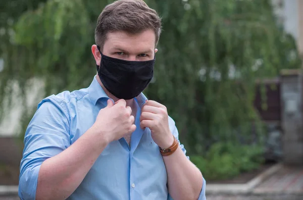 Social distance. Stop virus ! Young Man in Textile black cotton mask