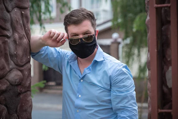 Social distance. Stop virus ! Young Man in Textile black cotton mask