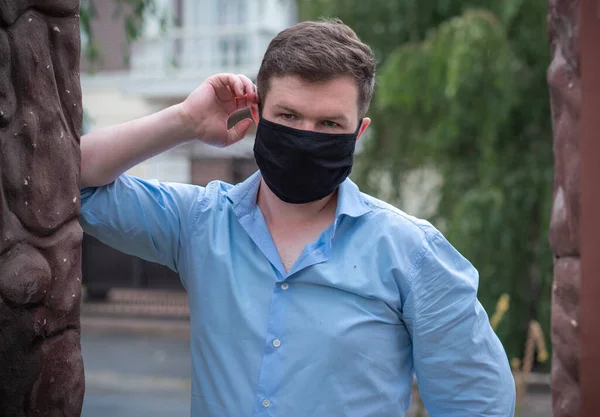 Social distance. Stop virus ! Young Man in Textile black cotton mask