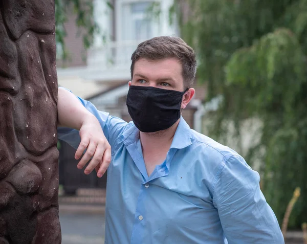 Social distance. Stop virus ! Young Man in Textile black cotton mask