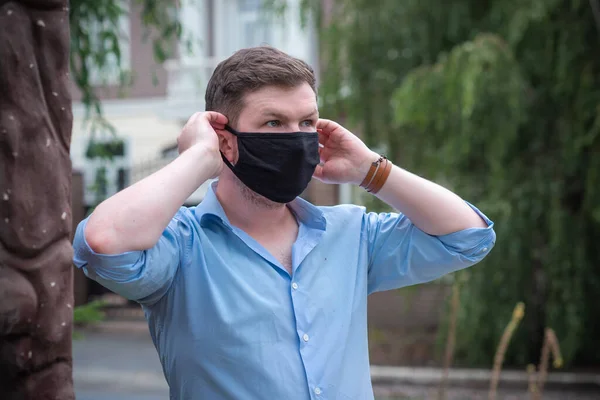 Social distance. Stop virus ! Young Man in Textile black cotton mask