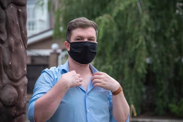 Social distance. Stop virus ! Young Man in Textile black cotton mask