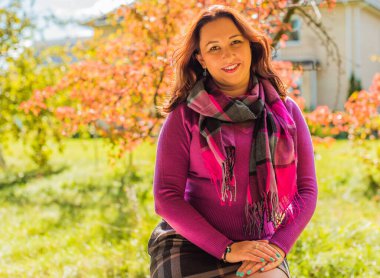 Sonbaharda gülümseyen güzel ve büyük beden modeli. Güzel bir sonbahar gününde gülümseyen büyük kızı kapatıyoruz. Yeni çağın standart güzelliğinin fotoğrafı.