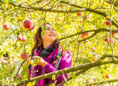 Sonbaharda gülümseyen güzel ve büyük beden modeli. Güzel bir sonbahar gününde gülümseyen büyük kızı kapatıyoruz. Yeni çağın standart güzelliğinin fotoğrafı.