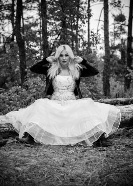 Ormanda beyaz elbiseli romantik bir gelin. Düğün konsepti kırsal bir tarzda. Gelinin güzelliği orman ve doğa, düğün modası ve giysi unsurlarıyla bir arada.
