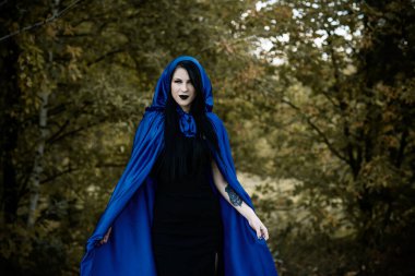 Cadılar Bayramı zamanı, cadılık, modern gotik kız mavi pelerinli kutlama. Fotoşoplar ve kostüm için iyi fikirler