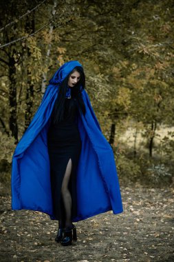 Cadılar Bayramı zamanı, cadılık, modern gotik kız mavi pelerinli kutlama. Fotoşoplar ve kostüm için iyi fikirler