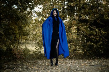 Cadılar Bayramı zamanı, cadılık, modern gotik kız mavi pelerinli kutlama. Fotoşoplar ve kostüm için iyi fikirler