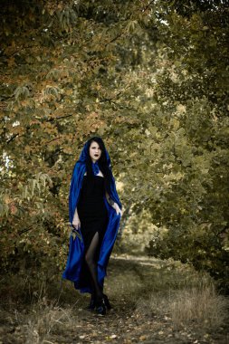Cadılar Bayramı zamanı, cadılık, modern gotik kız mavi pelerinli kutlama. Fotoşoplar ve kostüm için iyi fikirler