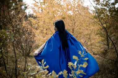 Cadılar Bayramı zamanı, cadılık, modern gotik kız mavi pelerinli kutlama. Fotoşoplar ve kostüm için iyi fikirler