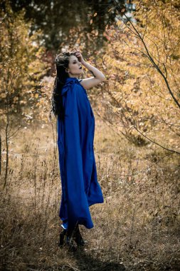 Cadılar Bayramı zamanı, cadılık, modern gotik kız mavi pelerinli kutlama. Fotoşoplar ve kostüm için iyi fikirler