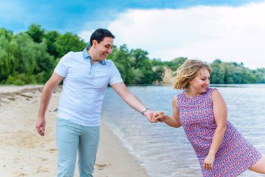 Mutlu orta yaşlı çift dışarıda eğleniyor ve gülümsüyor. Romantik mutlu çift öpüşüyor ve sarılıyor. Duygusal mutlu çift birbirine bağlanıyor.