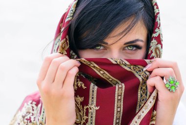 Elinde yüzük olan ipek eşarplı Arap bir kadın. Müslüman ülkelerde Avrupalı kadınların hayatı. Kadınlar için lüks aksesuarlar. Parlak yeşil gözlü bir kadın