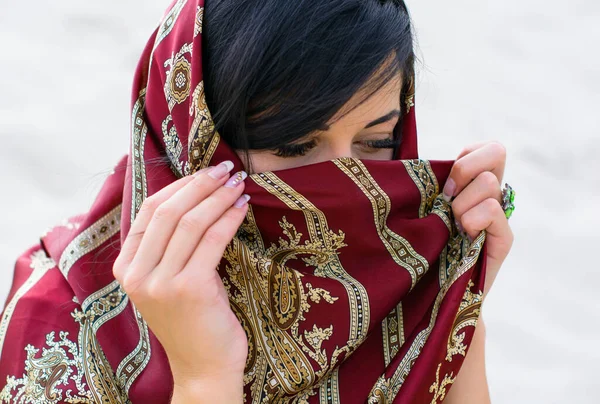 Arabic woman in a silk scarf with a ring on her hand. The life of European women in Muslim countries. Luxury accessories for women. A lady with bright green eyes