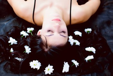 Siyah beyaz gecelikli seksi bir bebek ve çölde kumların üzerinde kumaşlar. Kumsalda poz veren rahat ve erotik muhteşem kadın.