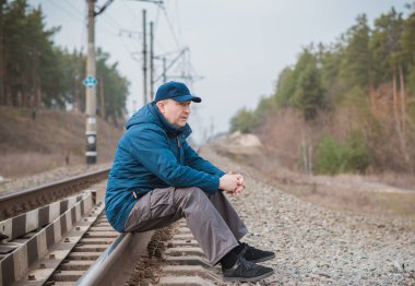 Demiryolundaki hayatını düşünen kıdemli bir adam. Olgun erkek psikolojisi.