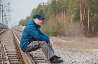 Demiryolundaki hayatını düşünen kıdemli bir adam. Olgun erkek psikolojisi.