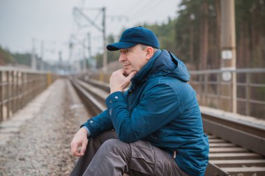 Demiryolundaki hayatını düşünen kıdemli bir adam. Olgun erkek psikolojisi.